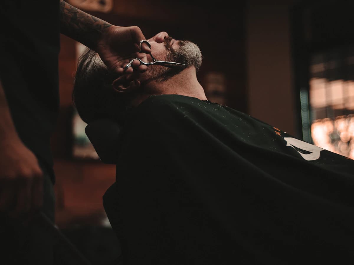 Barbier réalisant une taille de barbe
