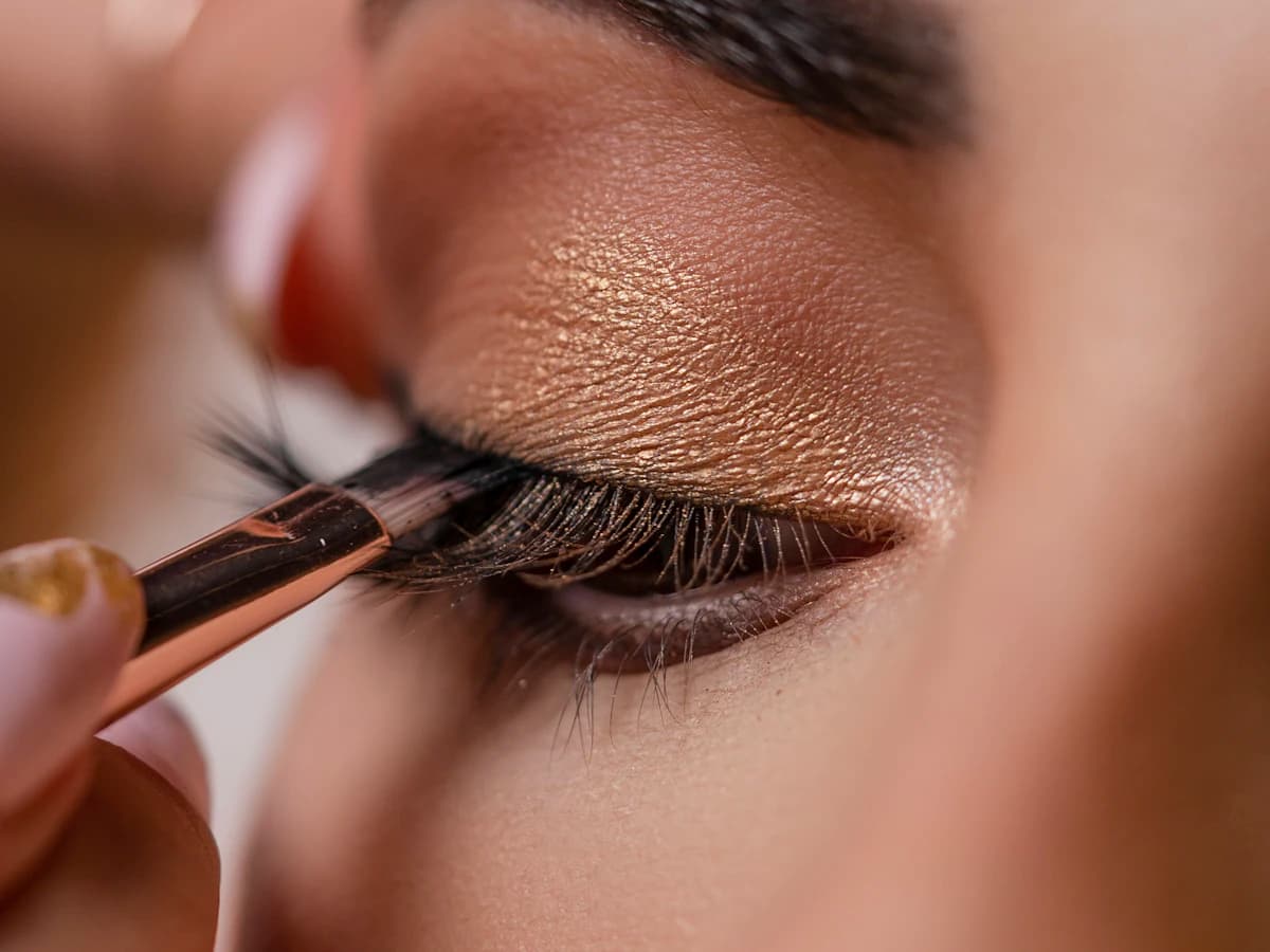 Maquilleuse appliquant un pinceau sur le visage d'une cliente